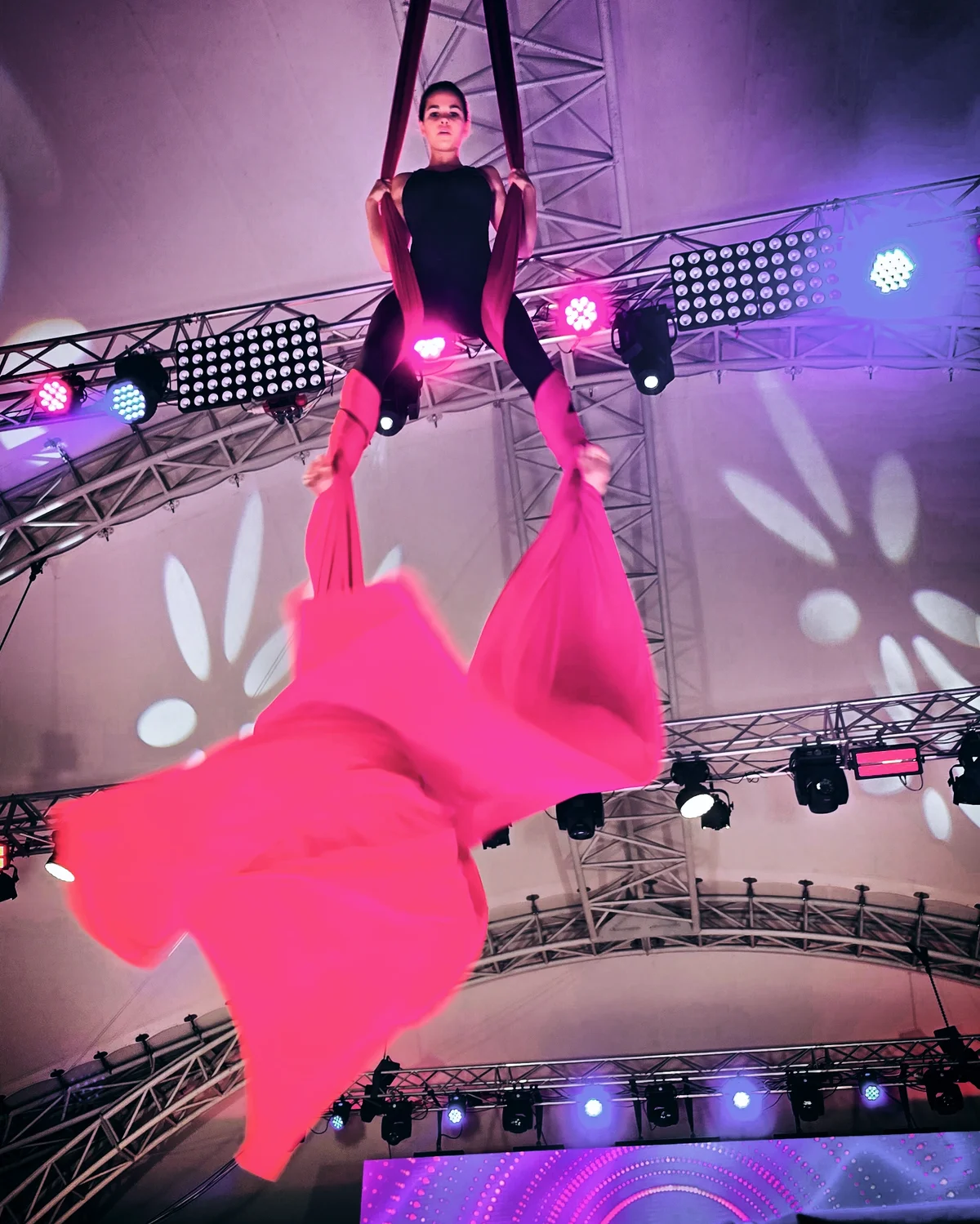 Anais Badina mid-drop on red aerial silks