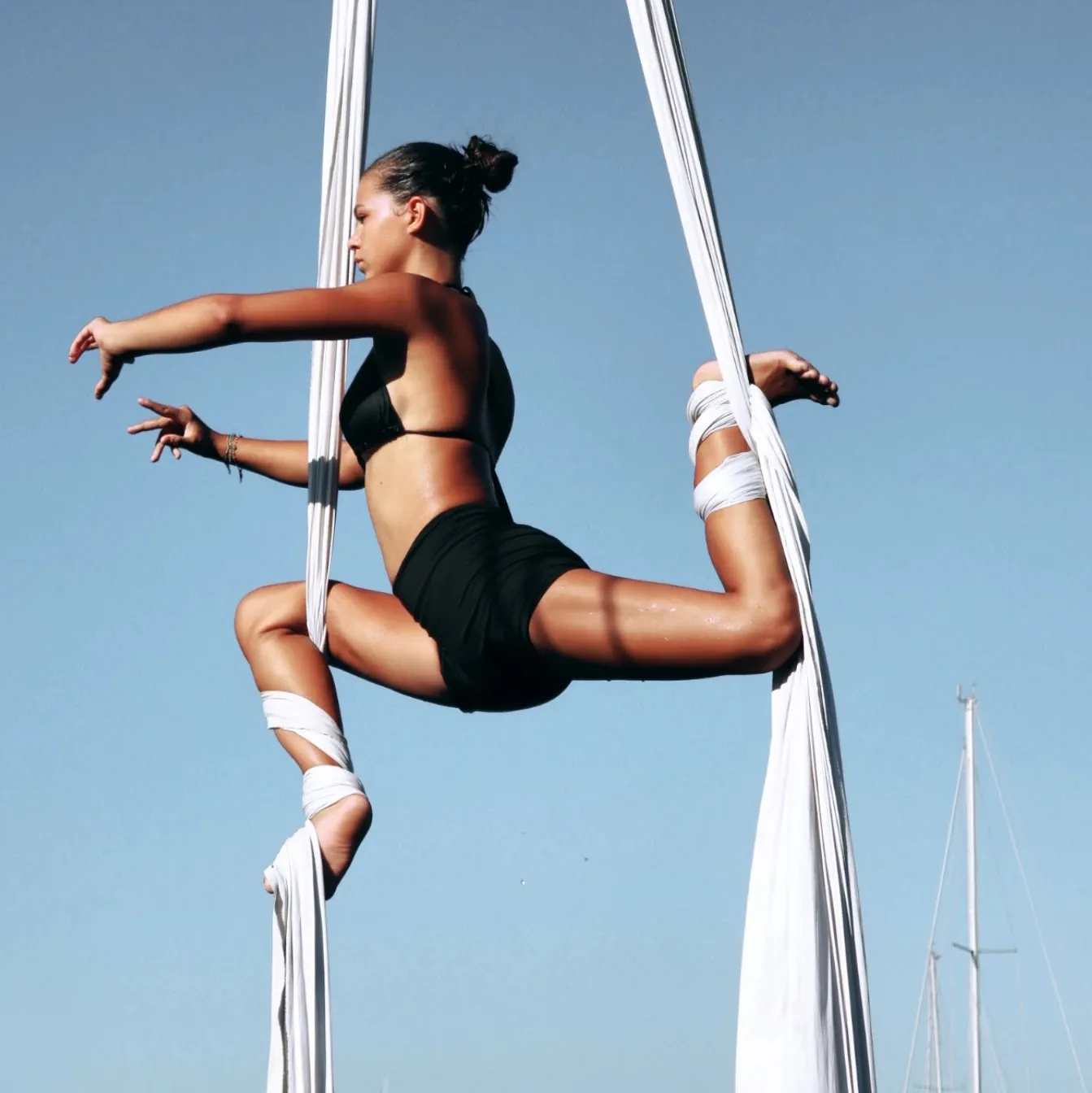Split held on white silks against a deep blue sky, a mast beside